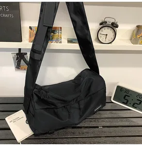 Dettaglio della borsa a tracolla nera in nylon resistente con tasche multiple a cerniera