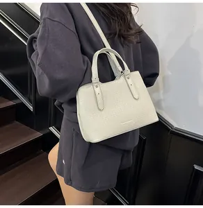 Dettaglio della borsa tote bianco crema in pelle martellata con manici superiori
