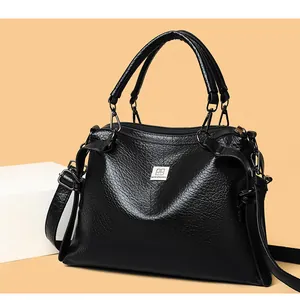 Close-up of black pebble leather handbag with silver logo and metallic hardware details