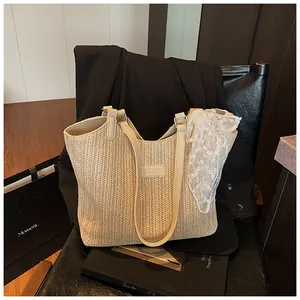 Detail of woven straw tote bag with elegant lace scarf and thin shoulder straps