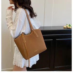 Detail of a brown woven tote bag showing texture and shoulder straps on a model