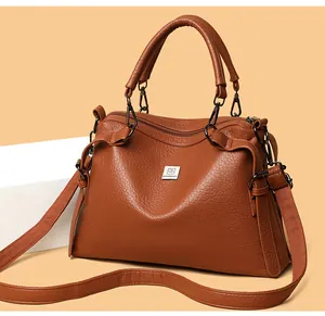 Detailed macro view of caramel lychee texture faux leather handbag and silver brand logo