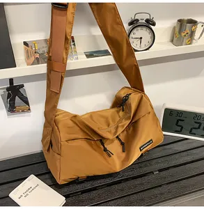 Dettaglio della borsa a tracolla grande in nylon marrone con tasche con zip