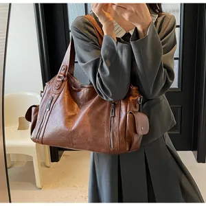 Détails d'un grand sac cabas marron foncé en similicuir avec poches zippées et bandoulière large
