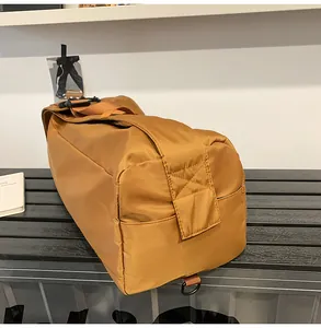 Dettaglio della borsa a tracolla in nylon marrone con cinghie resistenti e fibbia