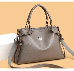 Detail of taupe leather tote bag with sturdy handle and gunmetal hardware accents