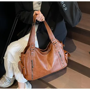 Détail d'un sac cabas en cuir PU marron avec double fermeture éclair et texture grainée