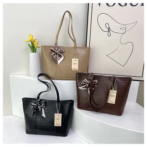 Détails de la texture crocodile sur les sacs cabas kaki, marron et noirs