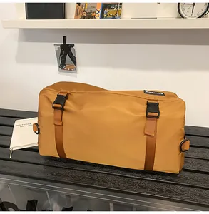 Dettaglio borsa a cilindro in nylon giallo senape con cinghie arancioni e fibbie