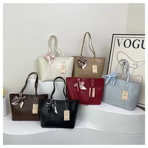 Détail de grands sacs fourre-tout à motif crocodile en six couleurs avec foulards soyeux