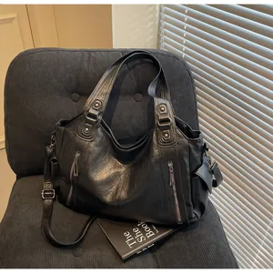Détails d'un grand sac fourre-tout noir en similicuir avec zips verticaux et bandoulière