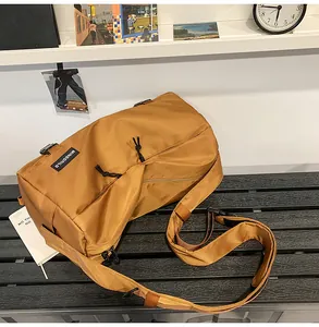 Dettaglio di una borsa a tracolla marrone in nylon con zip e logo MINGORILD