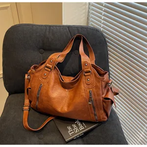 Détail du sac cabas en similicuir marron avec zips métalliques et bandoulière