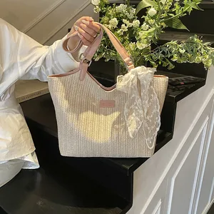 Minimalist woven tote bag with pink handles and lace bow detail for beach and daily commute