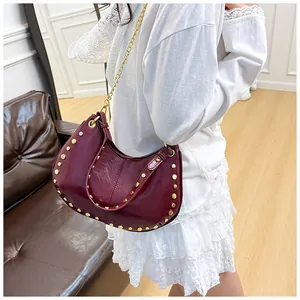 Vue détaillée du sac hobo bordeaux avec clous dorés et bandoulière sur le modèle