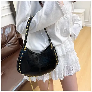 Détail du sac hobo en cuir craquelé noir avec clous dorés et bandoulière chaîne