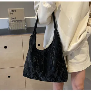 Détail du sac cabas en cuir froissé noir avec texture unique et étiquette de marque