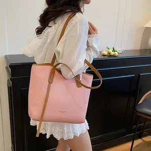Pink tote bag with contrast brown leather straps shown on model for daily commuting