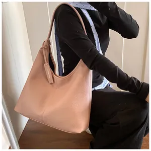 Détail d'un sac cabas rose en cuir grainé avec étiquette et large bandoulière chic