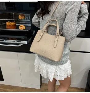 Borsa a mano beige testurizzata con manici e tracolla in un accogliente contesto di cucina