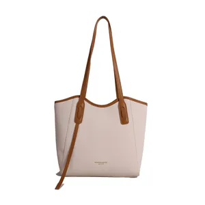 Minimalist cream tote bag with brown leather handles and woven texture finish