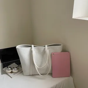 Detail of white woven tote bag showing spacious capacity for laptop and tablet