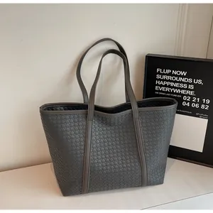 Detailed close-up of the woven texture and double handles on this grey tote bag