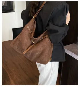Brown suede tote bag detail with slim shoulder strap worn with a black blazer for work