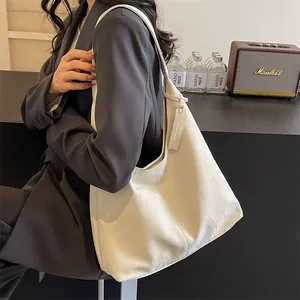 Sac fourre-tout crème minimaliste avec texture cuir plissé et étiquette décorative