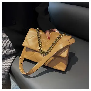 Detail van de gewatteerde kaki crossbodytas met gouden ketting en een leren riem