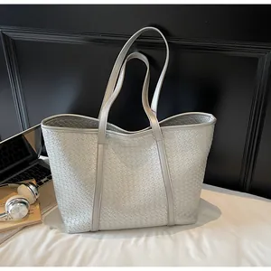 Detail of silver woven tote bag featuring metallic texture and large storage capacity