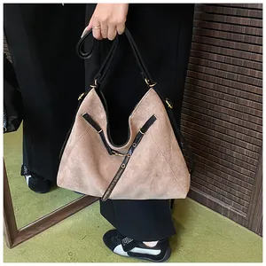 Detail of vintage suede tote bag with asymmetric zipper and bronze metal hardware