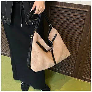 Detail of khaki tote bag with matte texture and black contrast shoulder strap