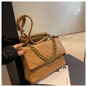 Detailopname van de karamel gewatteerde crossbodytas met gouden ketting en dubbele riemen