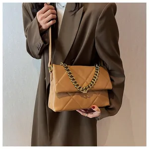 Detail van de karamel gewatteerde tas met grove gouden ketting en klepsluiting
