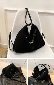 Detalle de bolso bandolera negro grande con textura de ante y hebilla metálica dorada
