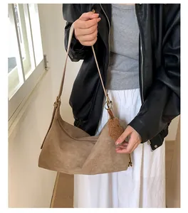 Brown faux suede crossbody bag with soft texture and cute plush bear charm detail