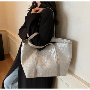 Close-up of silver woven tote bag featuring metallic finish and wide commute style