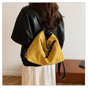 Vista trasera de un bolso tote de ante amarillo jengibre con correas de cuero negro