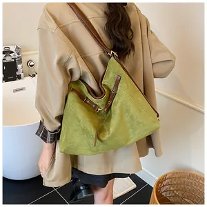 Retro green suede hobo tote bag with brown leather trim shown on a model