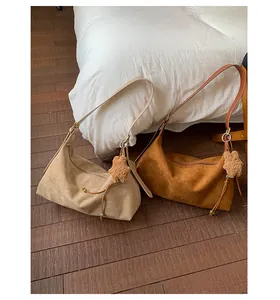 Detail of hobo crossbody bags in brown suede with star charms and beaded drawstring