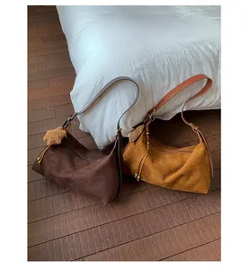 Close-up of large faux suede tote bags in dark brown and yellow with plush star charm
