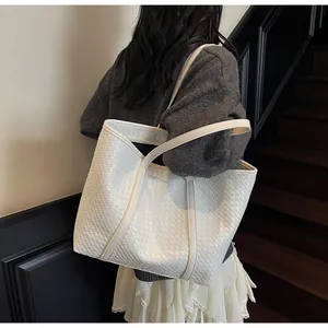 Close-up of the intricate white woven leather texture on a large shoulder tote bag