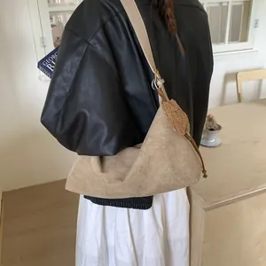 Vintage suede crossbody tote bag in tan brown with plush pendant shown on model