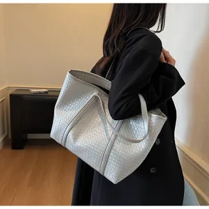 Detailed view of silver grey woven tote bag with intricate texture on a model