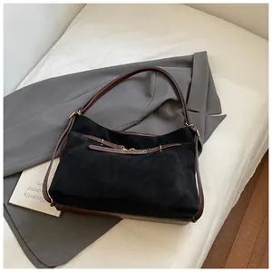 Detail of vintage tote bag showing black suede texture and brown leather strap contrast