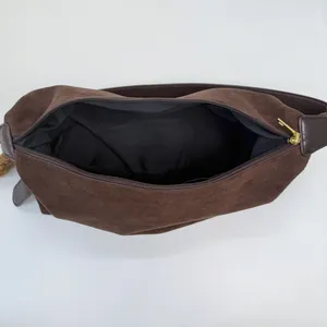 Brown faux suede crossbody hobo bag with spacious interior and gold zipper closure