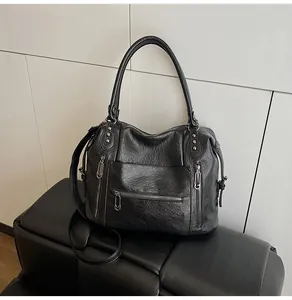 Close-up of soft black PU leather handbag featuring vintage texture and zip pocket details