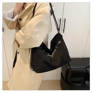 Elegante bolso tote grande negro llevado por una modelo con abrigo beige para un look a la moda