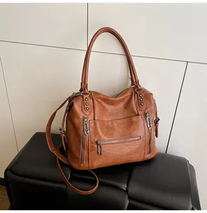 Detailed view of caramel brown tote bag with lychee texture and multiple zip pockets